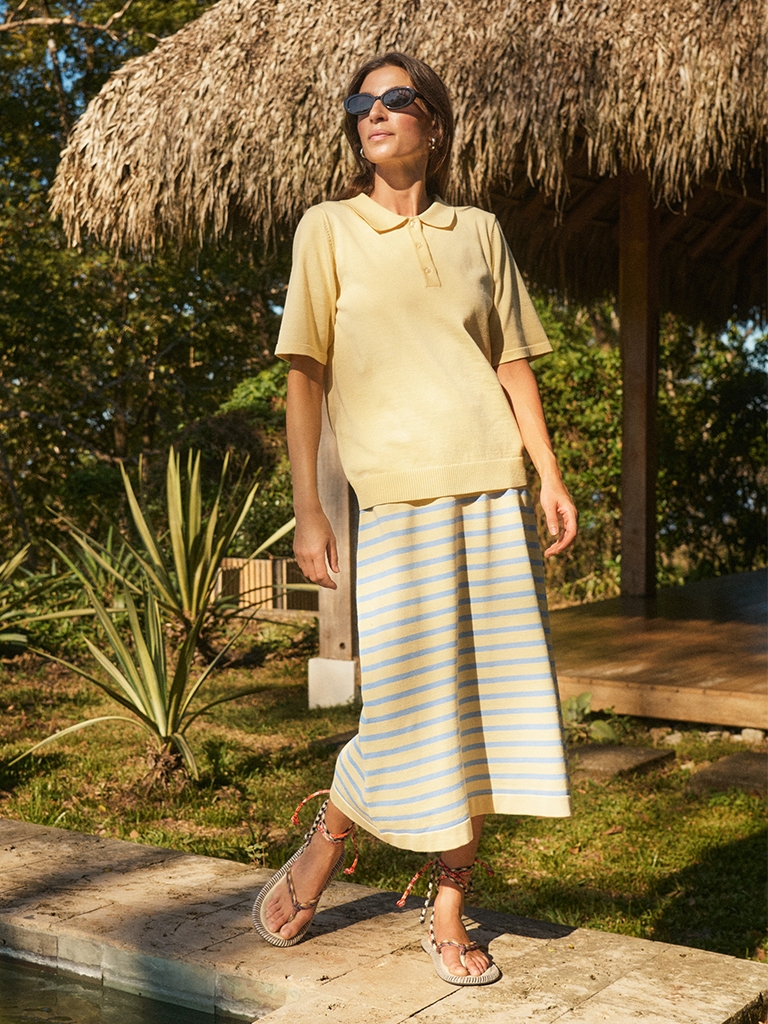 Girl on vacation i yellow polo and knit skirt