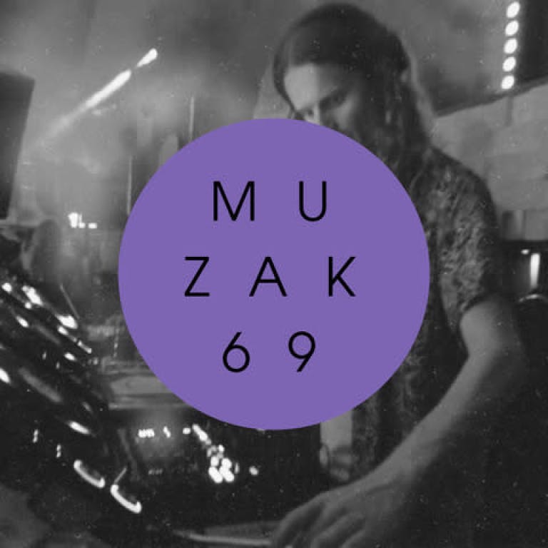 Man standing at a DJ booth. The image is black and white.