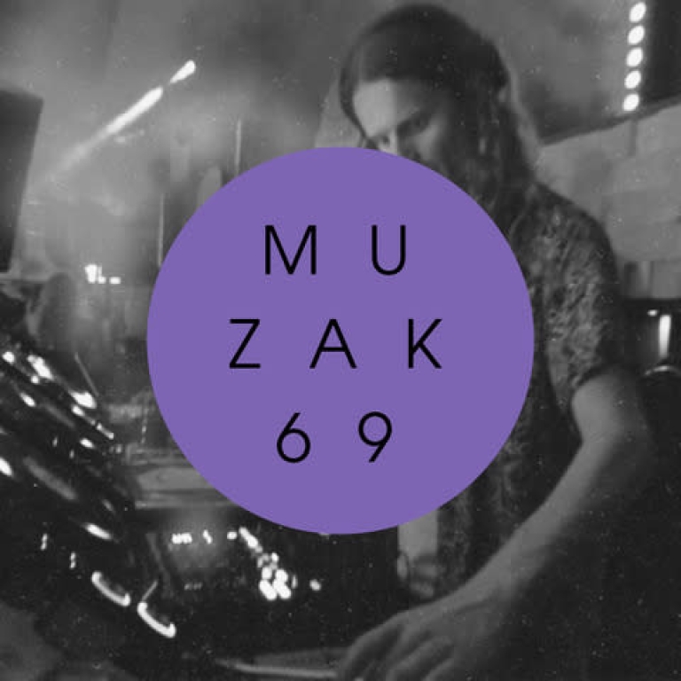 Man standing at a DJ booth. The image is black and white.